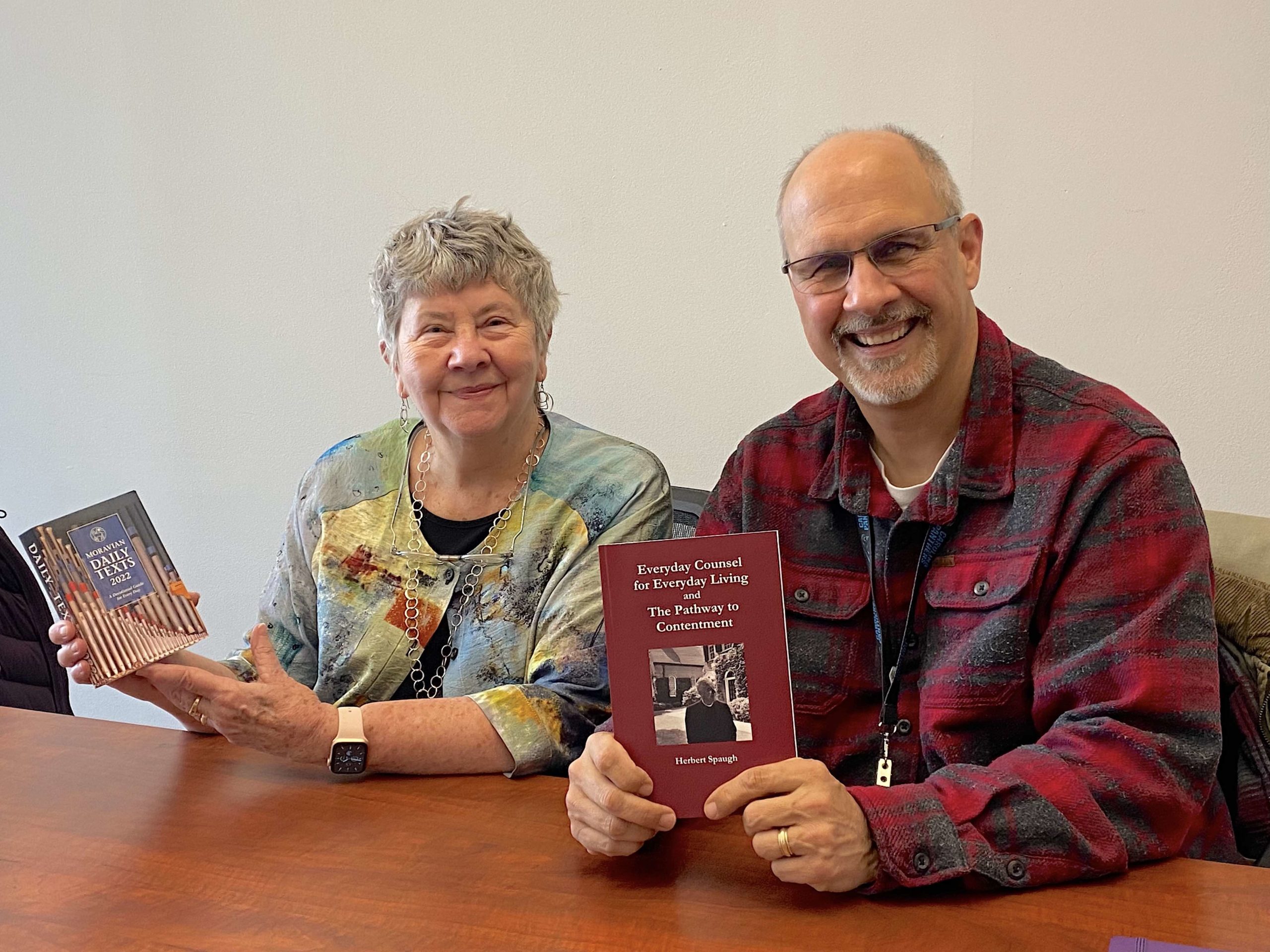 Margie Lamb, chair of Friends of Moravian Prison Ministry, and The Rev. Jeff Carter, chaplain for Forsyth Jail and Prison Ministry, holding the devotionals purchased with their grant from the Prison Ministry Field of Interest Fund, managed by the Moravian Ministries Foundation in America.